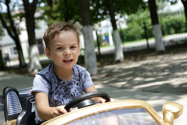 Boy driving a toy car in the park
