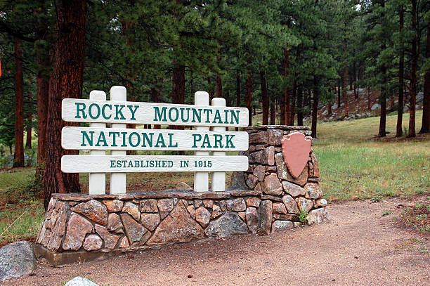 Close up of blank directional sign along an alpine path. Defocuses rocky peaks are in background.