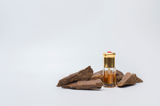 Botella de aceite de agarwood con incienso aislado sobre fondo blanco photo