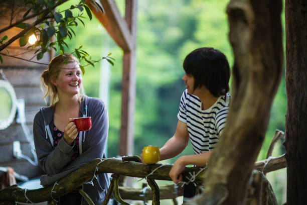 istock Young couple enjoying drinks on a balcony in a natural setting 955694510