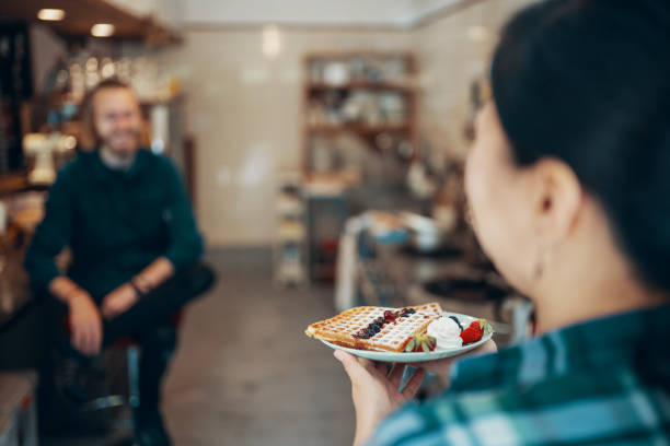 istock Female cafe owner with freshly prepared waffles in the kitchen 955694576