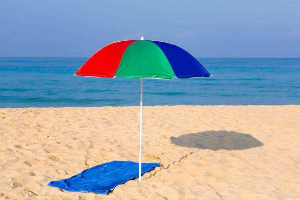 Beach umbrella and towel on a deserted beach. Karon, Thailand.
