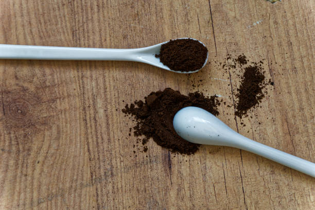 istock White ceramic spoon with coffee on wooden table, top view, kitchen background 955707186