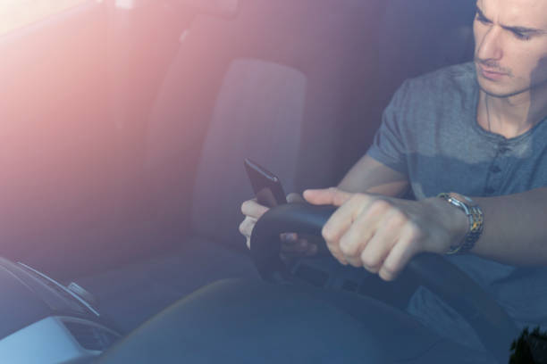 Don't text and drive Angry man driving car and texting message on smartphone. Dangerous driver. Don't text and drive. Distracted stock pictures, royalty-free photos & images