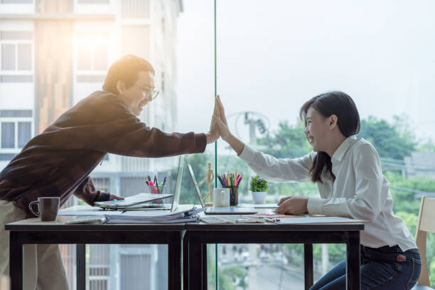 istock Happy young designers teamwork giving high five in office.Success and winning concept. 955722940