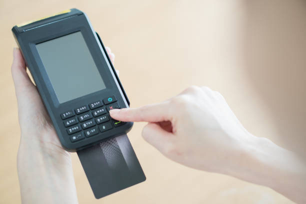 istock Hand with credit card swipe through terminal 955722958