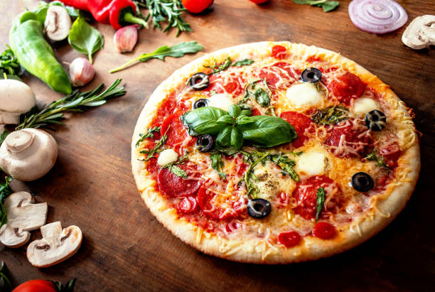 istock Food ingredients and spices for making Pizza  with  mushrooms, tomatoes, cheese and basil leaf  on wooden background closeup. Top view. Pizza Ready to Eat