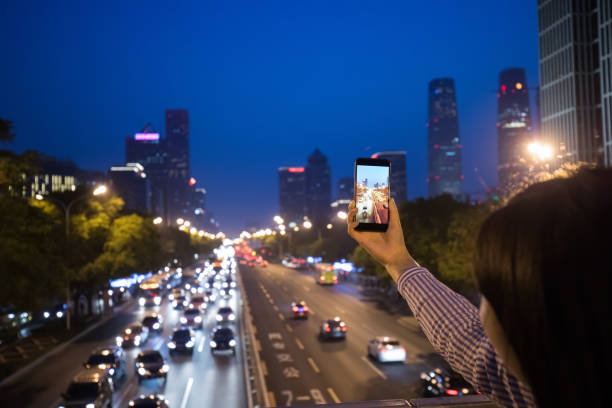 istock Taking pictures on smart phone in city night 955727966