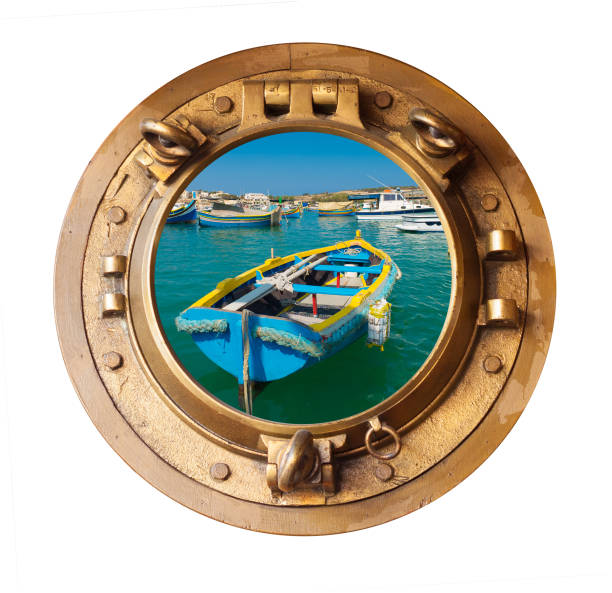 istock brass porthole and sunlit maltese rowing boat 955728276
