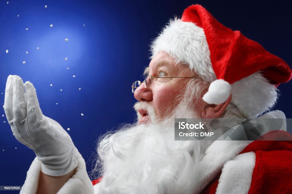 Father Christmas looking at snow falling onto his hand  Active Seniors Stock Photo