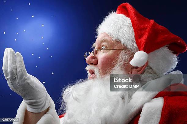 Father Christmas Looking At Snow Falling Onto His Hand Stock Photo - Download Image Now