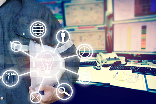 Double exposure of Engineer or Technician man with business industrial tool icons holding safety hat with monitor of computers room  for oil and gas industrial business concept.