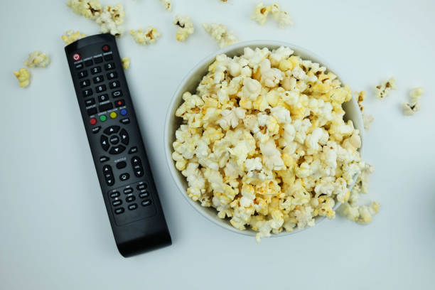 istock Top view of popcorn and remote control on white background 955733672