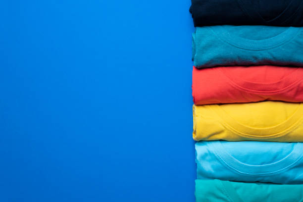 istock close up of rolled colorful clothes on blue background 955737300