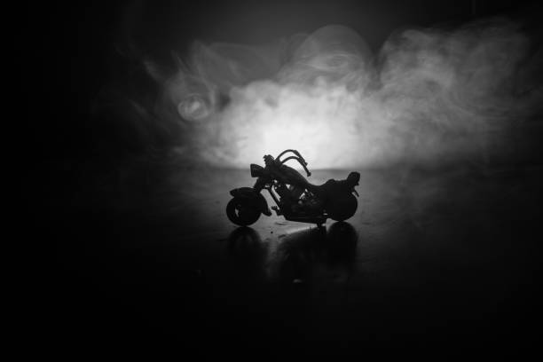 istock High power motorcycle chopper. Fog with backlights on background with man rider at night. Empty space 955738042