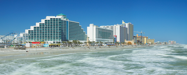 daytime view of the skyline of Daytona Beach - the main city of Florida’s Fun Coast region. Located between Orlando and Jacksonville, the city is known for many miles of sandy beaches where cars are allowed during daylight hours. It  is home to the Daytona International Speedway and the NASCAR headquarters.