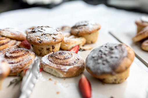 A delicious, freshly baked chocolate chip muffin and pastries frosted or spinkled with icing sugar on a business breakfast buffet in the UK