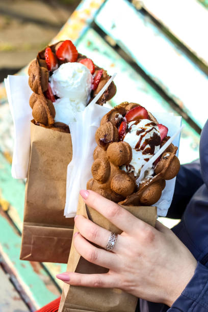 istock Bubble waffles with ice cream in woman hand. 955752280