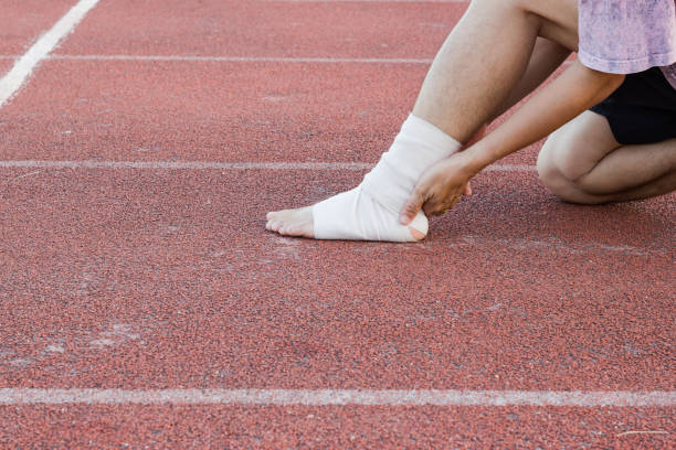 istock Male athlete applying compression bandage onto ankle injury 955755762