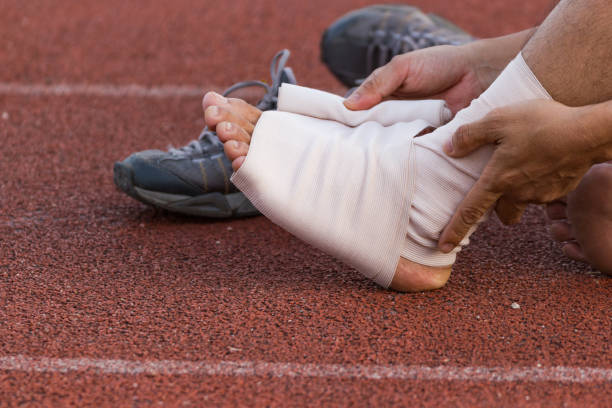 istock Male athlete applying compression bandage onto ankle injury 955755776