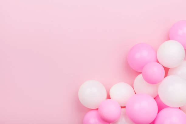 istock Pastel pink table with colorful balloons for birthday top view. Flat lay style. 955756708