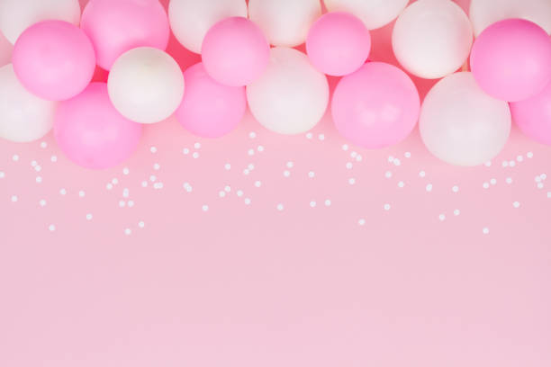 istock Pastel balloons and white confetti on pink background top view. Flat lay. 955756926