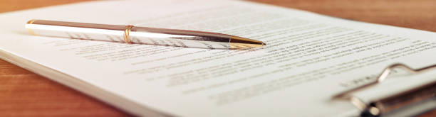 penna sdraiata su un contratto o un modulo di domanda, vista grandangolare. - contract signing document legal system foto e immagini stock