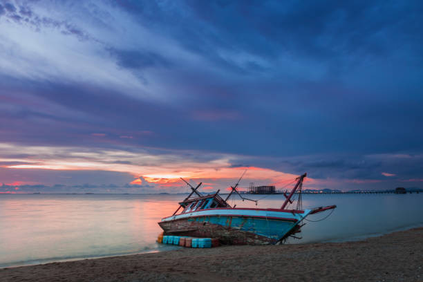 istock Wreck was left on the beach with the beautiful twilight sky. 955760044