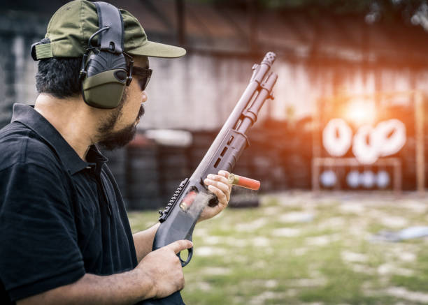 vista de un hombre con una escopeta de recargar el cartucho. - armed forces human hand rifle bullet fotografías e imágenes de stock