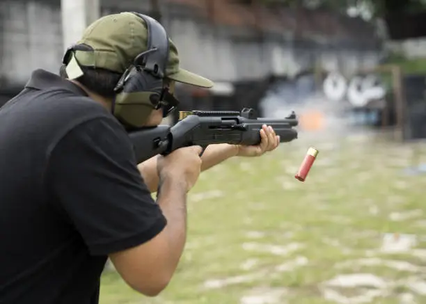 Photo of Man shooting on an outdoor shooting range, selective focus