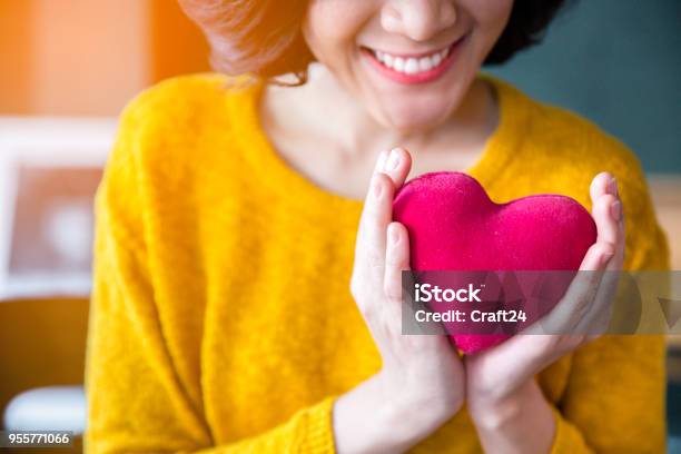 Woman Hands In Yellow Sweater Holding Pink Heart Stock Photo - Download Image Now - Heart - Internal Organ, Heart Shape, Healthy Lifestyle