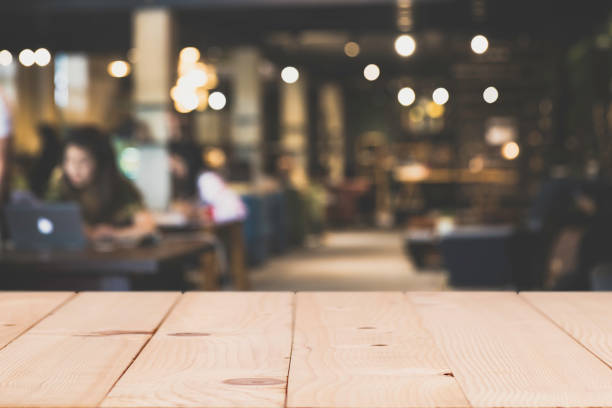 istock Wood Table top Counter with blurred of coffee shop or modern library . Abstract, freelancer working on laptop. 955771206