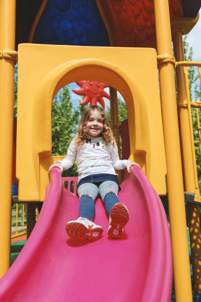 istock Happy little girl having fun with sliding 955771698