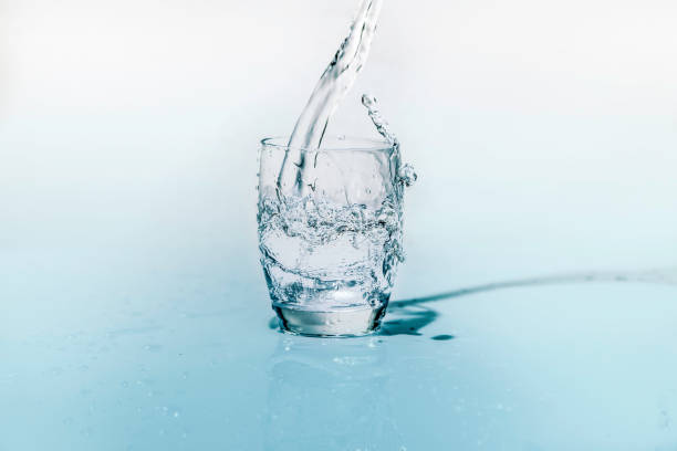 istock glass of fresh water while it is being poured from the bottle 955771708