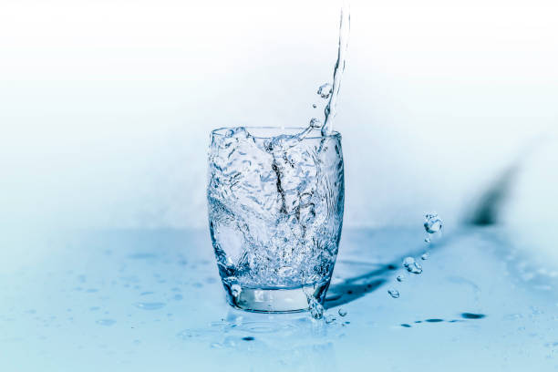 istock glass of fresh water while it is being poured from the bottle 955771710