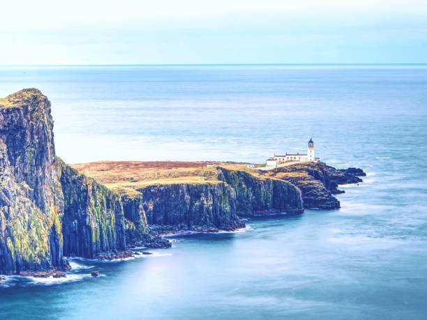 istock Neist Point peninsula with lighthouse. Foamy blue sea strikes against the sharp cliff 955772792