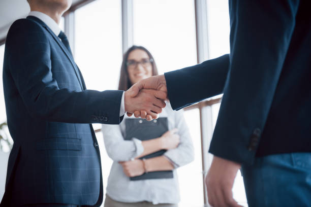 istock Two confident business man shaking hands during a meeting in the office, success, dealing, greeting and partner concept 955776206