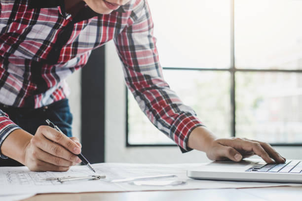 istock Construction concept, Hands of architect or engineer working for new project plan on blueprint, model building and engineering tools in working site 955777502