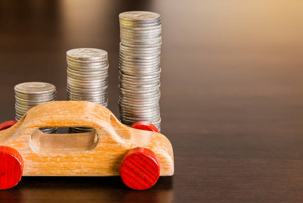istock Stack of coins with wooden car on wood table 955779010