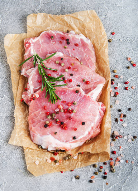 istock Fresh raw pork chops with spices and herbs 955780730