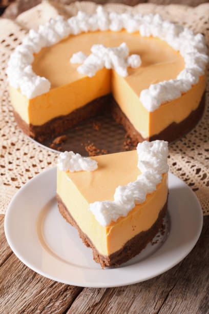 istock Cut pumpkin cheese cake decorated with whipped cream close-up. vertical 955781556