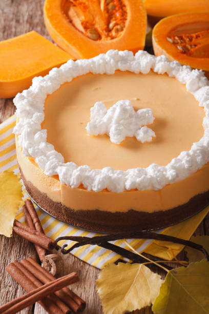 istock pumpkin cheesecake with cinnamon, vanilla and whipped cream close-up. Vertical 955781588
