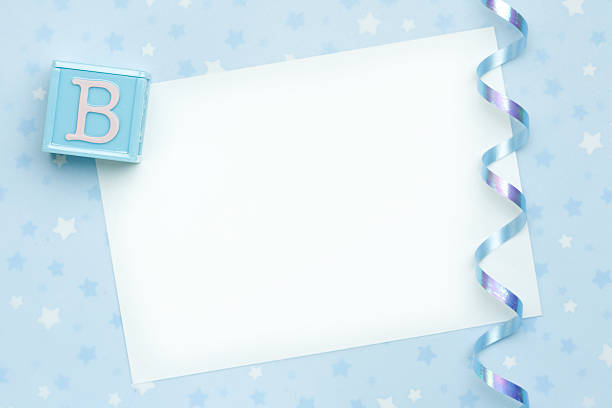 Blank paper with ribbon and blue block representing new baby Blank card for a new baby or baby shower invitation baby shower card stock pictures, royalty-free photos & images