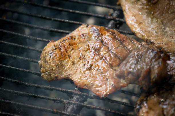 istock Barbecue lunch. Grilled meat chops in a black cast iron pan, close-up. 955788154