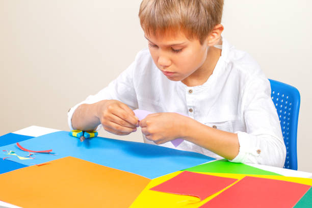istock Child making greeting card with colored paper at the table 955788640
