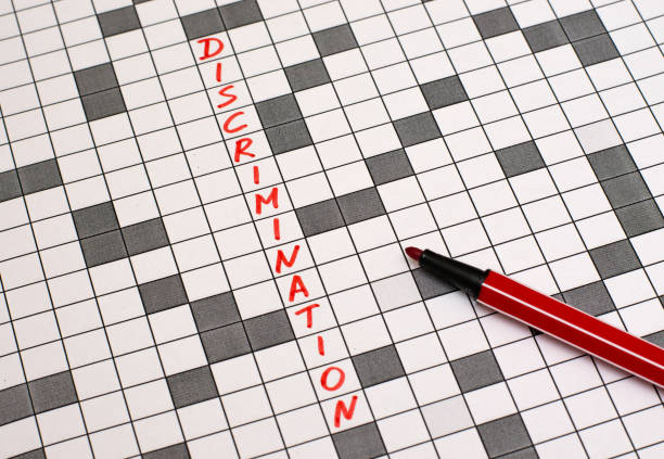 istock Discrimination. Text in crossword. Red letters. Close-up 955788792