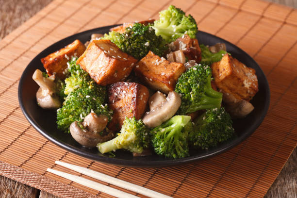 gebratener tofu mit brokkoli, pilzen und teriyaki sauce nahaufnahme käse. horizontale - tofu chinese cuisine vegetarian food broccoli stock-fotos und bilder