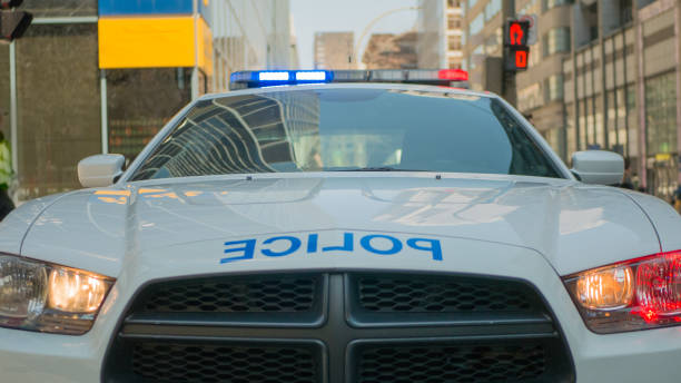 Saint John, New Brunswick, Canada - November 26, 2017: A police car with its red and blue lights on travels at high speed down the center of a city street.