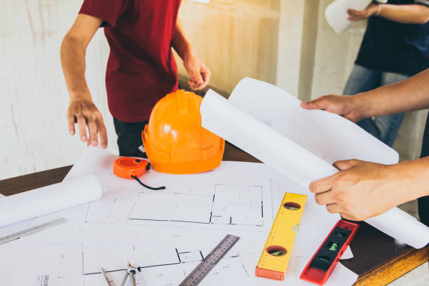 istock Construction workers and chiefs or architects are meeting on the interior design of the housing project on blueprint. 955790828