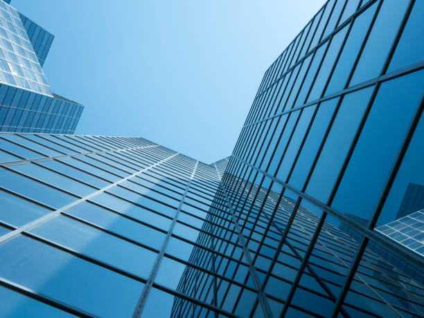 vista angolare dell'edificio moderno con un cielo blu chiaro sullo sfondo - building exterior glass window built structure foto e immagini stock